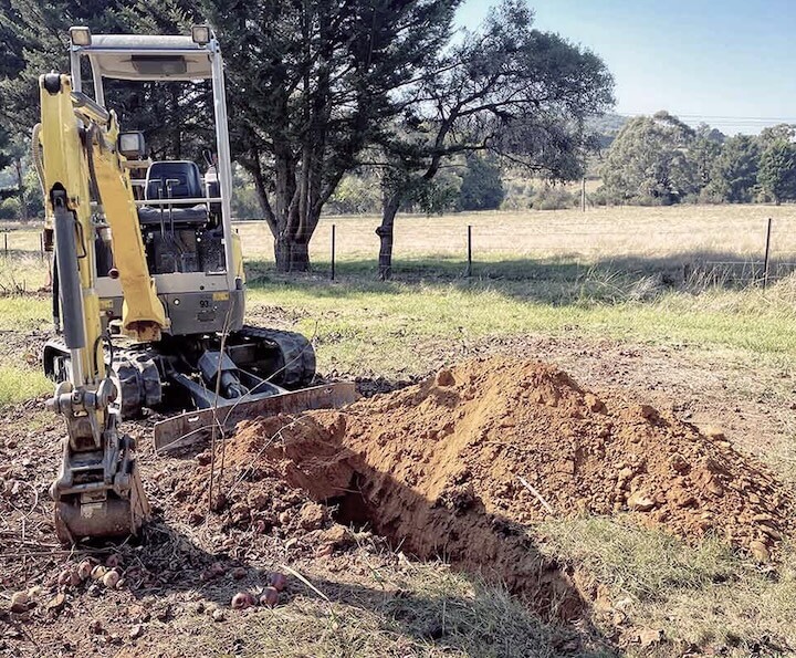 Construction digging equipment next to hole.